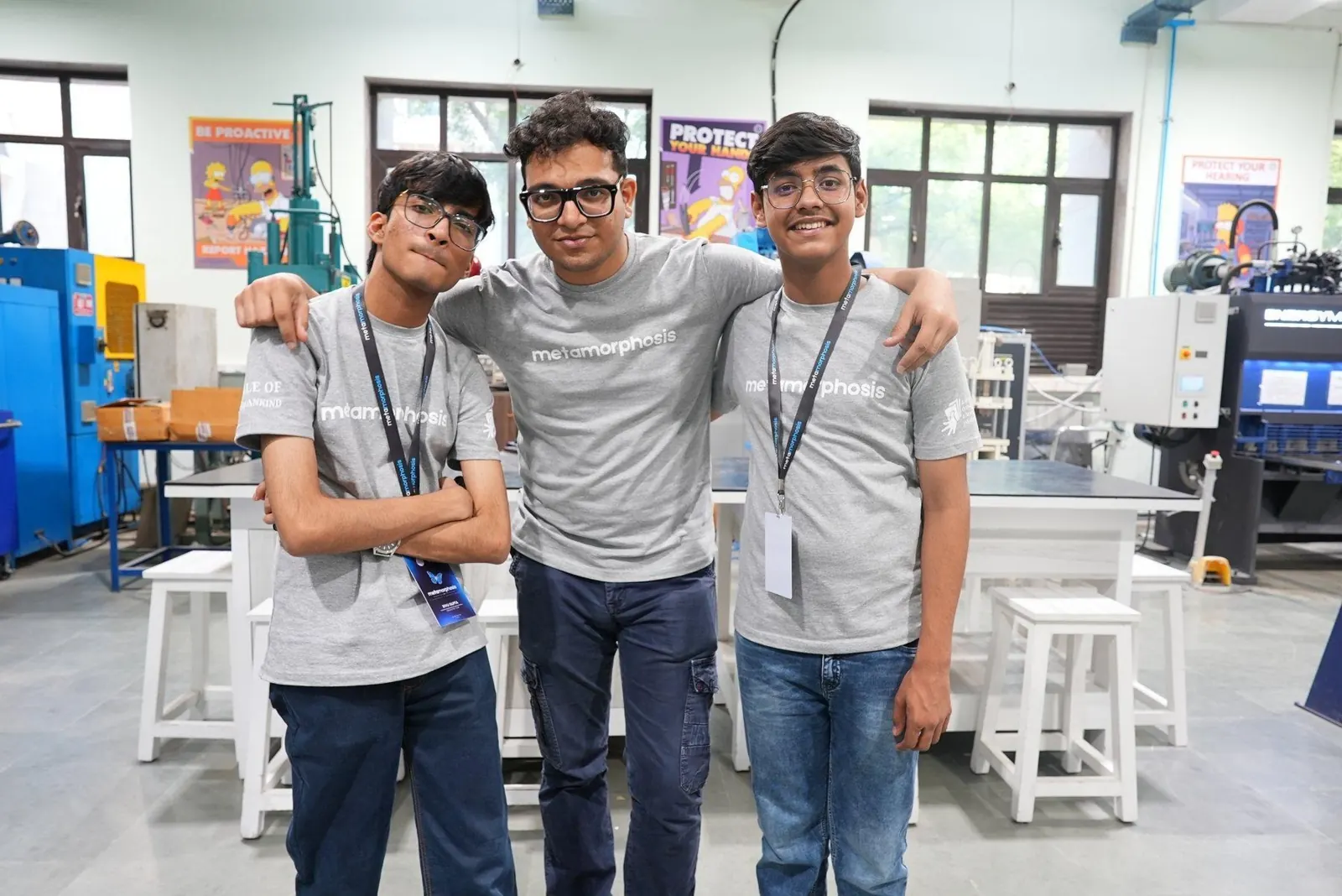 Three young builders standing together inside a fabrication lab